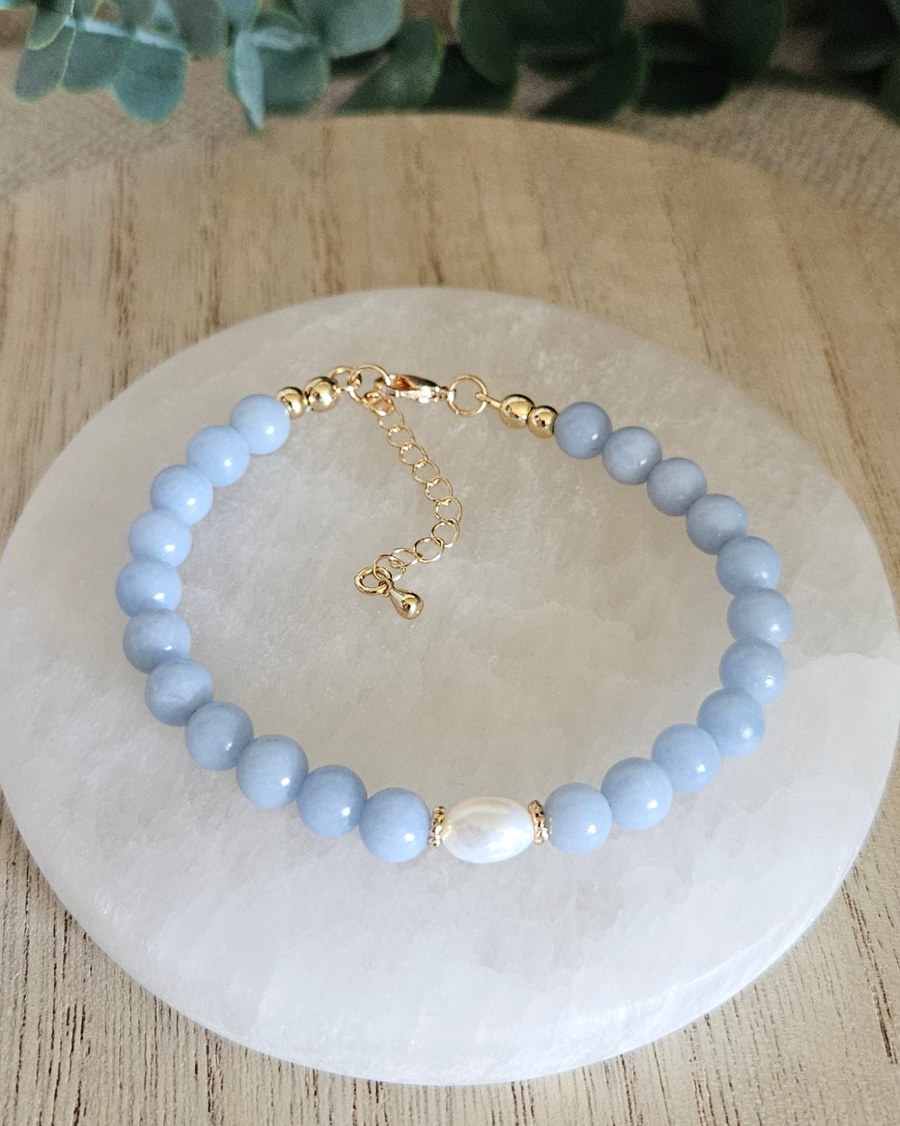 Overhead view of the Angelite Embrace bracelet with freshwater pearl focal, clasp and extender chain