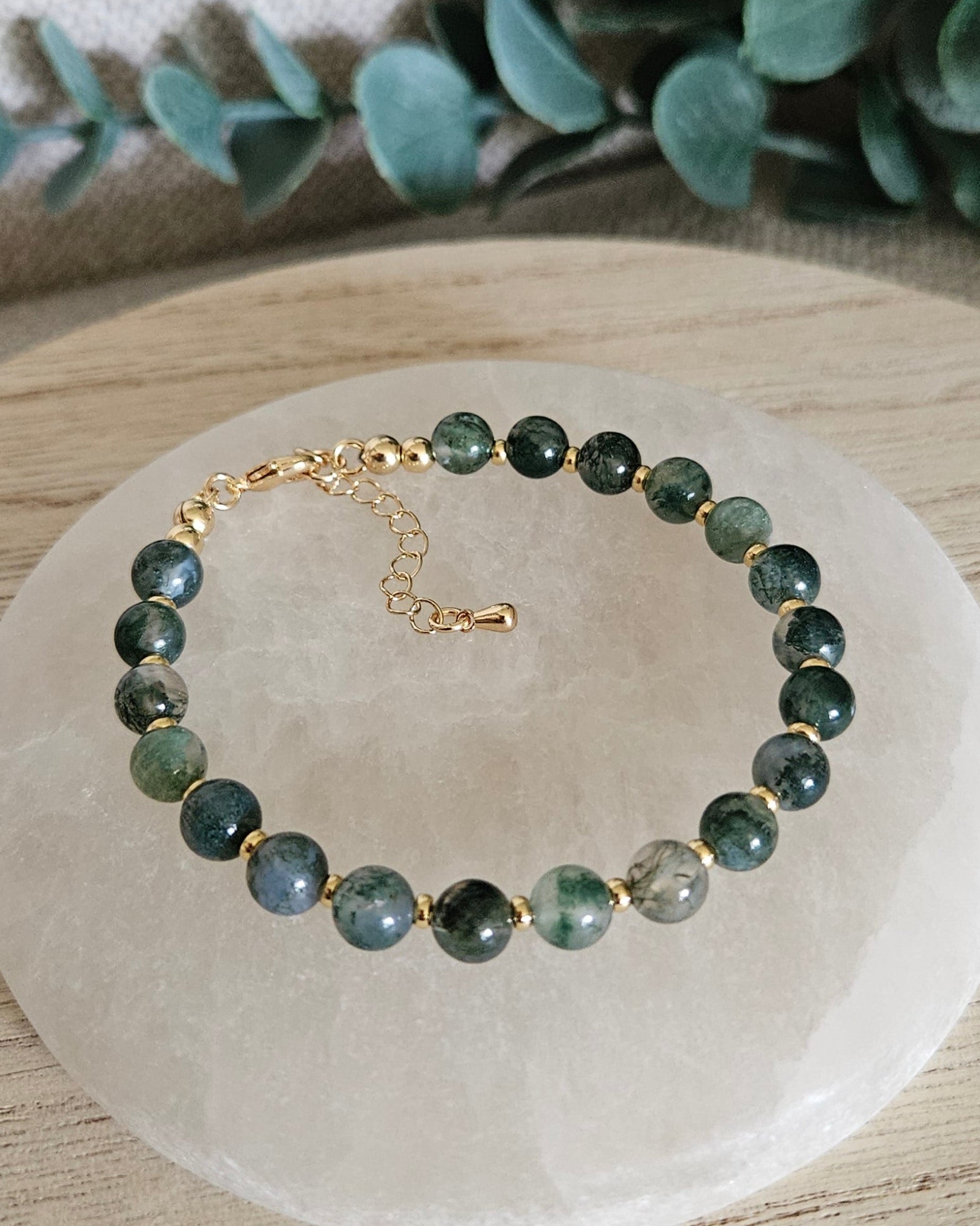 Overhead view of the Moss Agate Echo bracelet with gold-plated clasp and extender chain on selenite