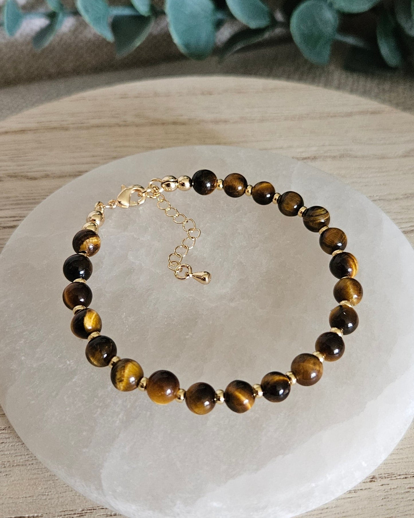 Full view of the Tiger’s Eye Echo bracelet with gold-plated clasp and extender chain on selenite