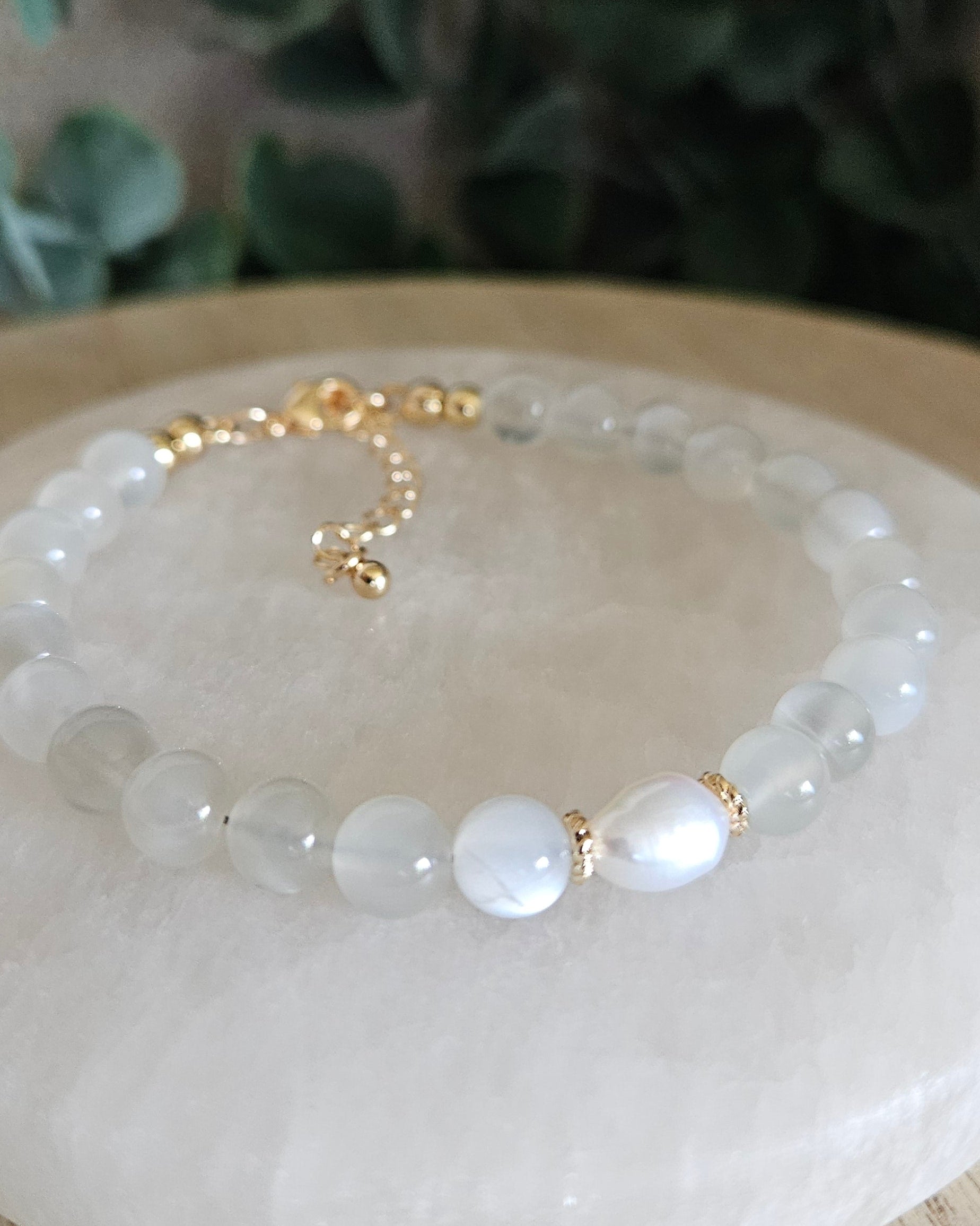 Close-up of peach White Moonstone beads and a freshwater pearl focal with gold-plated floral spacers